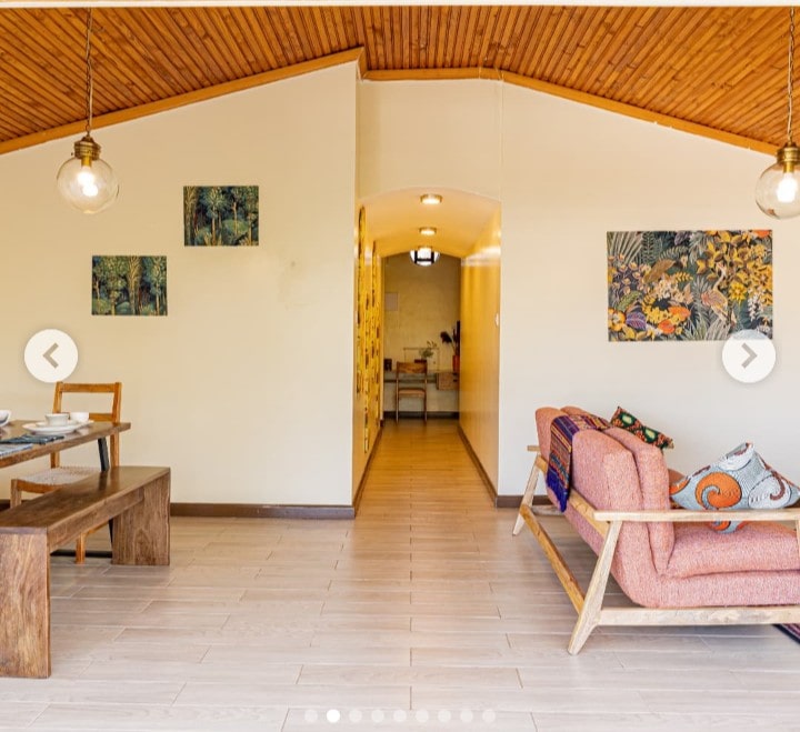 Spacious, fully furnished living room at Grove Penthouse with large windows and garden views