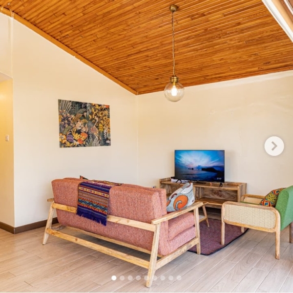 Spacious, fully furnished living room at Grove Penthouse with large windows and garden views